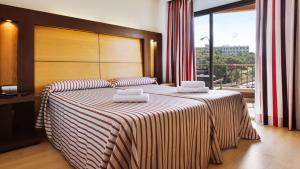 a bedroom with a large bed with two pillows on it at Hotel Pabisa Chico in Playa de Palma
