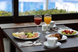 a table with plates of food and two glasses of juice at Hotel Pabisa Chico in Playa de Palma
