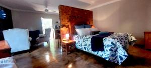 - une chambre avec un grand lit et une chaise dans l'établissement THE POT AIRBNB, FAERIE GLEN, PRETORIA EAST, à Pretoria