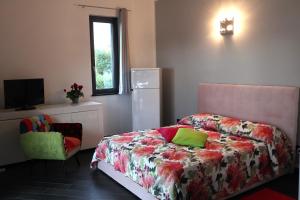 1 dormitorio con 1 cama, TV y silla en Suite con vista, en Vezzi Portio