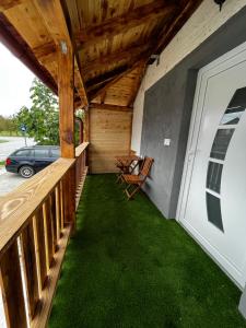 a porch with green grass and a wooden deck at Venite Rooms in Velika