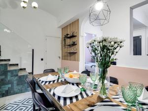 une salle à manger avec une table et un vase de fleurs dans l'établissement Townhouse with private terrace and 4 Bedrooms, à L'Hospitalet de Llobregat