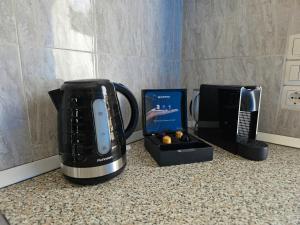 Galini Apartments Sikinos Travel في سيكينوس: آلة صنع القهوة وغيرها من الأجهزة على منضدة