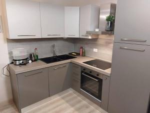 eine Küche mit weißen Schränken und einem Waschbecken in der Unterkunft Appartamento ristrutturato 2021 in Bardonecchia