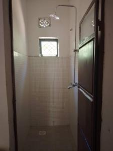 een badkamer met een douchecabine en een raam bij Kioga home stay in Arusha