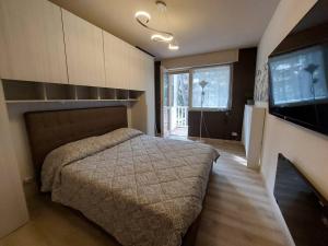 ein Schlafzimmer mit einem Bett und einem TV in der Unterkunft Appartamento ristrutturato 2021 in Bardonecchia