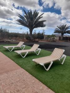two white lounge chairs sitting on the grass at Villa Oliva Fuerteventura in Tuineje