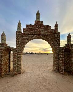 a brick archway in the middle of the desert at Luxury Camp Dunes Insolites Sabria in Sabria