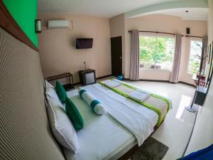 um quarto grande com uma cama grande e almofadas verdes em O2 Ella em Ella