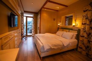 a bedroom with a bed and a television in it at Piazza Boutique Hotel in Batumi