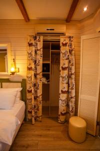 a bedroom with a bed and curtains and a stool at Piazza Boutique Hotel in Batumi