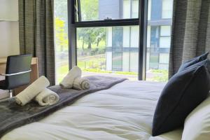 a bedroom with a large bed with towels on it at The Simpson - Luxury 2 bed - Private Parking in Edinburgh