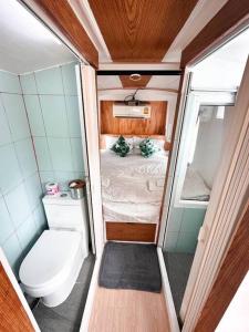 a small bathroom with a toilet and a bed at Baan Bus 81/11 Krabi in Ao Nang Beach