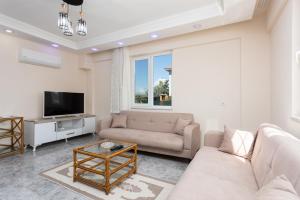 a living room with a couch and a tv at Villa Corals in Dalyan