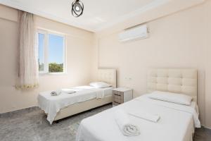 two beds in a white room with a window at Villa Corals in Dalyan +29 photos