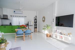 a living room with a table and blue chairs at 哦先生的海景别墅 in Phuket Town