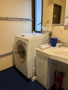 Matsukawaにある離れの宿 かぶろの庭の洗面台の横にある浴室の洗濯機