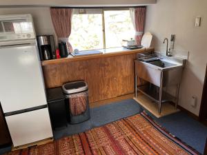 a small kitchen with a sink and a refrigerator at 離れの宿　かぶろの庭 in Matsukawa