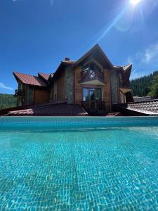 a house with a swimming pool in front of a house at Girskiy Prutets in Bukovel