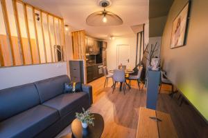 un salon avec un canapé bleu et une table dans l'établissement La Villa Relax SPA Luxe, à Amiens