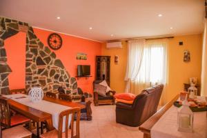 een woonkamer met oranje muren en een stenen open haard bij Large Villa with pool, garden near Trasimeno Lake 
