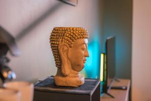 une statue d'une tête assise sur une table dans l'établissement La Villa Relax SPA Luxe, à Amiens