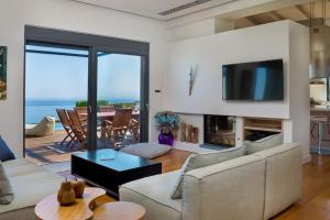 a living room with a couch and a tv and a table at Villa Pasiphae in Stalos