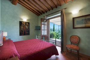 ein Schlafzimmer mit einem roten Bett und einem Fenster in der Unterkunft VILLA SAN NAZARIO 18&2, Emma Villas in Asciano
