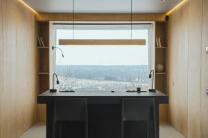 OposhnyaにあるOBRIY holiday villageの黒い島と大きな窓のあるキッチンが備わります。 +124枚の写真