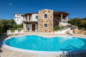 a villa with a swimming pool in front of a house at Villa the Queen in Budoni
