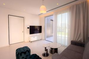 a living room with a couch and a tv at City Napa Seaview Villas - Villa 8 in Ayia Napa