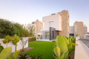 a house with a yard with green grass at City Napa Seaview Villas - Villa 8 in Ayia Napa