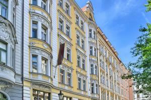 a yellow building with white windows on a street at Milosrdnych Apartments in Prague