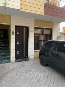 een auto geparkeerd voor een huis bij Odyin Apartment in Mohali