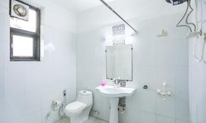 a white bathroom with a sink and a toilet at FabHotel F9 H Block Sector 51 in Noida