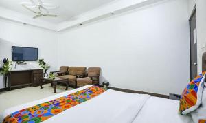 a bedroom with a bed and a living room at FabHotel F9 H Block Sector 51 in Noida