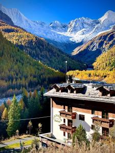 a building with snowy mountains in the background at Hotel Gembro in Chiesa in Valmalenco