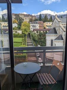 - Balcón con vistas, mesa y silla en Joli studio proche des thermes en Aix-les-Bains