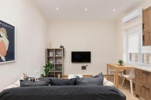 sala de estar con sofá y TV en Mikrolimano Gem: Serene 1BR Apartment en Piraeus