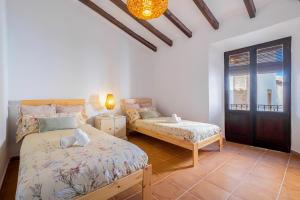 a bedroom with two beds and a window at La iaia Rosita Preciosa casa tradicional Jávea in Jávea