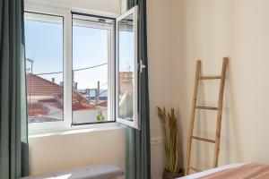 a room with a ladder and a window with a view at Mikrolimano Gem: Serene 1BR Apartment in Piraeus