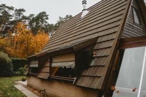 una casa con techo de tejas y ventana en Boshuisje Rekem - Flora en Lanaken