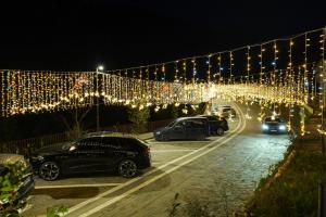 una fila de autos estacionados en un estacionamiento con luces en Hotel Uji Ftohte Tepelene, en Tepelenë