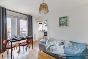Un dormitorio con una cama y una mesa y sillas. en Cocon Urbain à 2 pas de la Gare, en Nantes