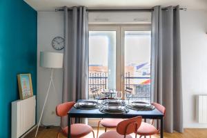 d'une salle à manger avec une table, des chaises et une fenêtre. dans l'établissement Cocon Urbain à 2 pas de la Gare, à Nantes