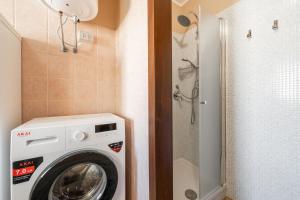 une machine à laver dans une salle de bain avec douche dans l'établissement Le Sabbie Bianche, à Calasetta