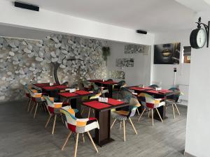 a dining room with tables and chairs and a clock at Pensiunea Bavaria Campina in Campina