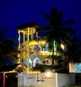 budynek na plaży w nocy w obiekcie Light of Zanzibar Hotel w mieście Nungwi