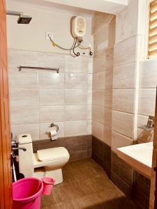 a bathroom with a toilet and a sink at Orange Corner Hotel, MONTHLY STAY AVAILABLE in Yelahanka