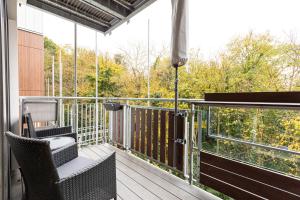 a balcony with chairs and a view of trees at Immaculate 2BR Flat, Greenwich, 2 min Maze Hill St in London